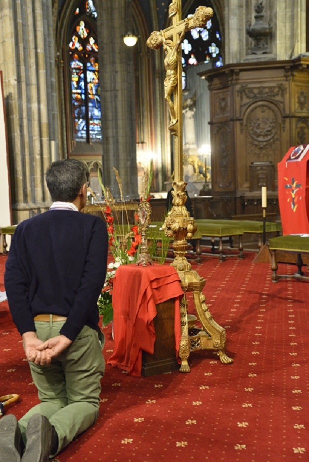 Homme en prière devant un crucifix